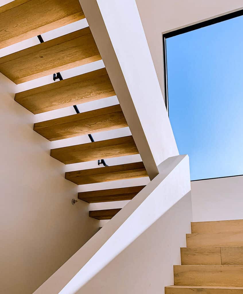 Escadas interiores em madeira com corrimão branco